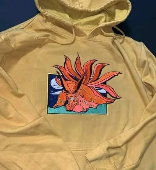 Orange nine-tailed fox embroidery on a yellow hoodie