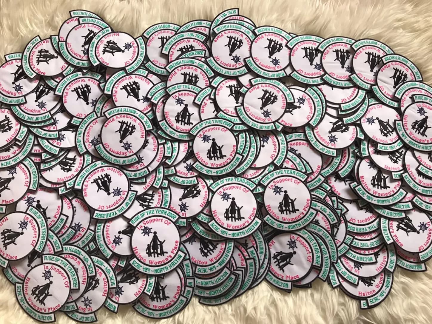 Round patches with green and pink lettering and rider silhouettes