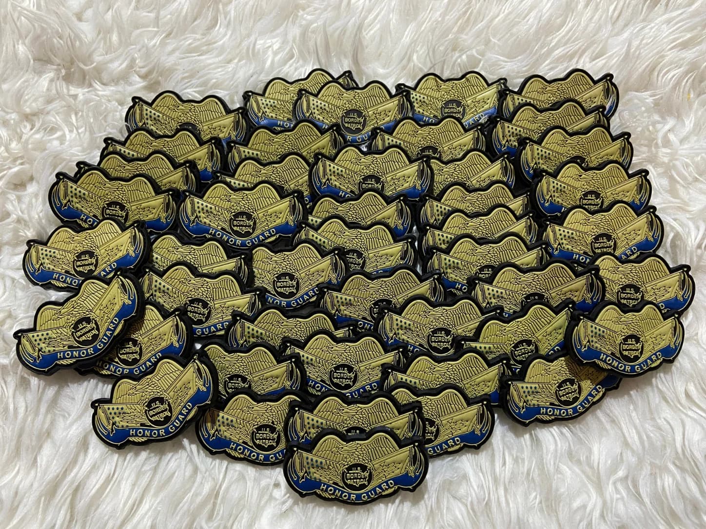 Gold eagle-shaped badge patches arranged in a batch